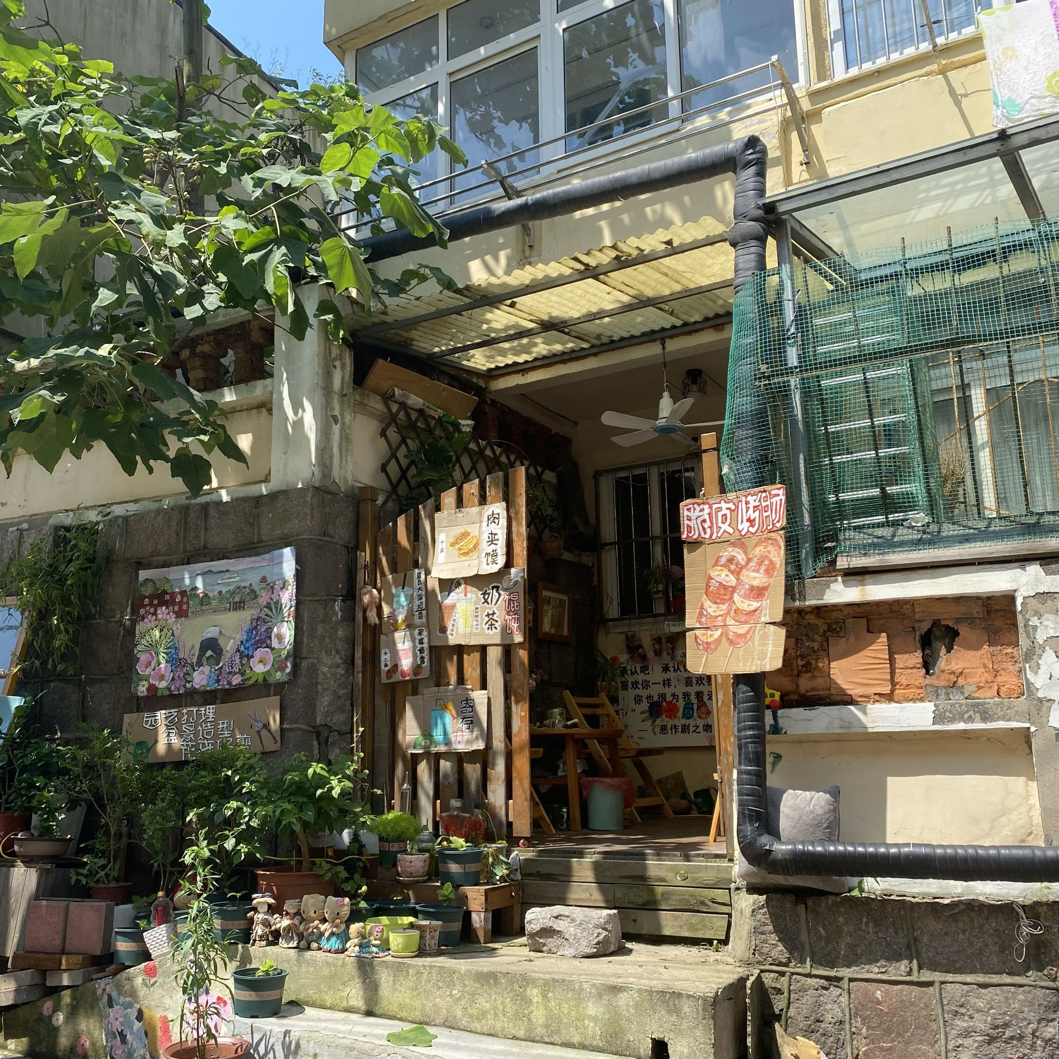 This is a kiosk at the bottom of the hill with some hand-painted food photos hanging outside.